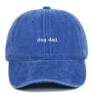 Detail of white Dog Dad embroidery on washed blue cotton baseball cap surface