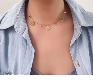 Detail of a stainless steel gold chain necklace featuring purple crystals on a model