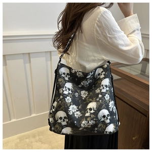 Detailed view of black nylon crossbody bag with white skull and flower prints