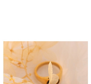 Gros plan détaillé d'une bague coeur dorée minimaliste sur un fond artistique doux
