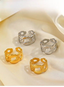 Detail of adjustable chain link rings set in gold and silver on soft beige silk background
