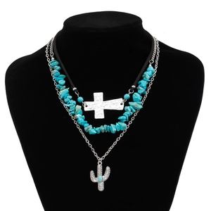 Detail of bohemian layered necklace with turquoise stones, cross and cactus pendants