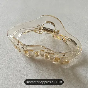 Detail of 11cm transparent champagne wavy hair claw clip with golden metal spring