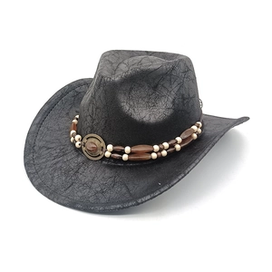 Close-up of black suede cowboy hat with vintage texture and beaded turquoise badge