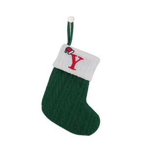 Close-up of green knitted Christmas stocking with white cuff and red letter Y embroidery