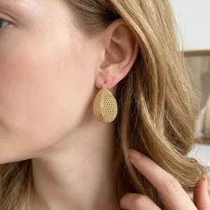Vintage gold hollow woven oval hoop earrings with a drop shape on model for women