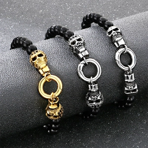 Trois bracelets punk à perles avec crânes en finitions or, argent et gris fusil