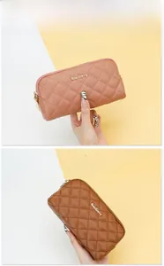 Detailed view of quilted long wallets in dusty pink and dark brown with zippers