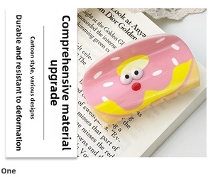 Close-up of pink donut-shaped acrylic hair claw clip on a book background