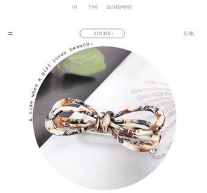 Macro detail of tortoiseshell pattern bow hair clip with silver metal spring fastener