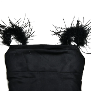 Gros plan d'une robe en satin noir avec bretelles en plumes et col bénitier chic