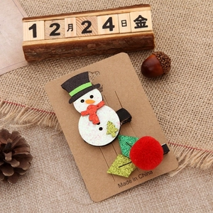 Christmas hair clips set featuring a glittery snowman and red pom-pom holly berries