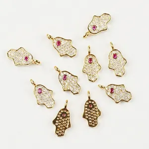 Detailed Hamsa charm with white zircon and purple stone next to coin for size