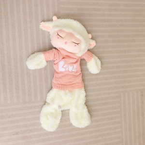 Close-up of sheep plush toy in pink knitted sweater with LOVE lettering detail