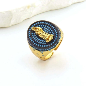 Detail of wide gold ring featuring a Virgin Mary relief and turquoise stone inlay