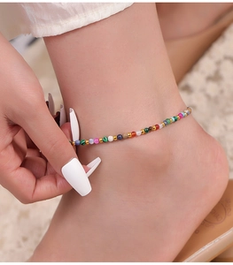 Close-up of handmade anklet with colorful natural stones and 18k gold-plated beads