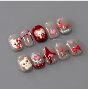 Detailed view of 3D cartoon nail charms featuring cute bears, cherries and hearts on red tips