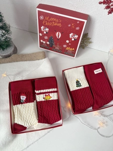Détail des chaussettes de Noël rouges et blanches dans une boîte cadeau brodée