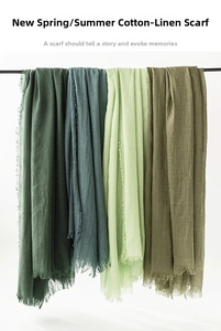 Detailed view of layered cotton linen scarves with fringe edges in earthy green tones