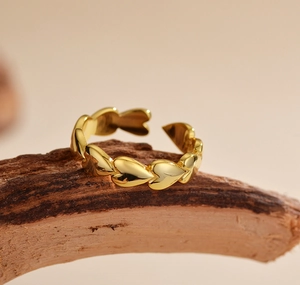Macro view of golden heart-shaped minimalist ring on natural wood background