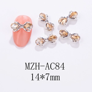 Makroaufnahme von 14x7mm Schleifen-Nagel-Schmuck mit Strasssteinen auf weißem Hintergrund