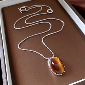 Macro shot of an oval resin pendant on a silver-tone beaded chain with a vintage OT toggle clasp