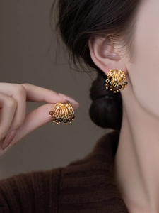 Detail of retro gold tassel earrings with tiger eye beads and sparkling crystals