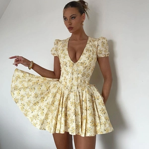 Détail d'une robe fleurie à col en V avec imprimé jaune et manches bouffantes