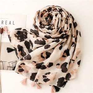 Dettaglio sciarpa leopardata con riflessi metallici scintillanti e lunghe frange moda