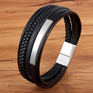 Dettaglio di bracciale multistrato in pelle con piastra in metallo spazzolato e chiusura