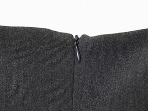 Detailed close-up of invisible zipper on dark gray twill fabric with precision stitching