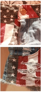 Dettaglio di pantaloncini in denim con motivo bandiera americana, frange ed chiusura a bottone