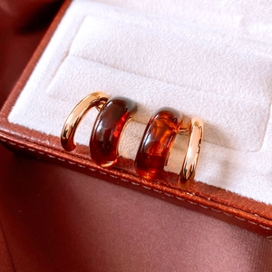 Detailed macro view of retro C-shape resin earrings with 18K gold plated metal texture