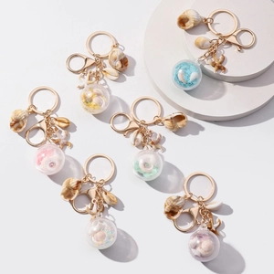 Oceaan-sleutelhangers met glitterballen, schelpen en zeesterren in zes pastelkleuren