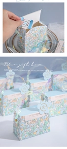 Close-up of blue floral wedding gift box with handle and heart-shaped paper gift tag