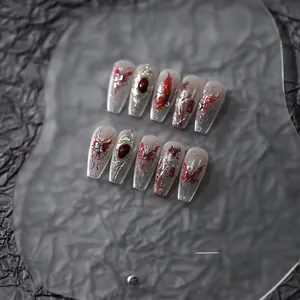 Detailed view of 10-piece Gothic press-on nails with red butterflies and silver metal accents