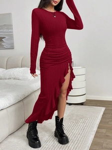 Close-up of ruched waist and ruffled side slit on burgundy ribbed knit dress