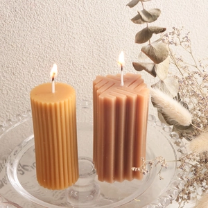 Detalle de velas de pilar acanaladas en bandeja de cristal para decorar el hogar