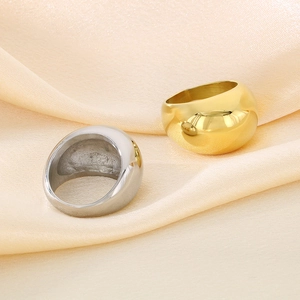Close-up of chunky dome rings in gold and silver finish on champagne silk background