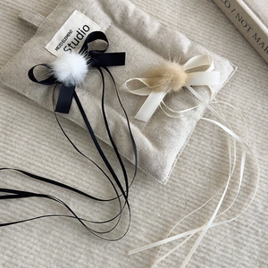Detail of ballet style long ribbon bow hair clips with soft pompom decor for girls