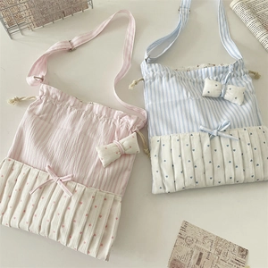 Detailed top view of striped drawstring crossbody bags with bow accents and ruffle trim