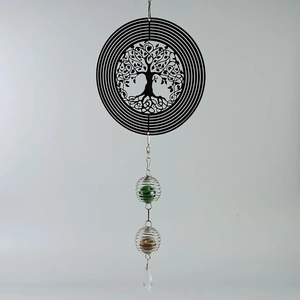 Detail of tree of life wind spinner with green and bronze spheres and crystal drop