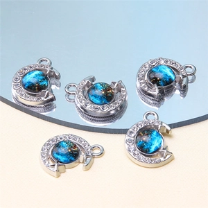 Macro detail of crescent moon pendant with blue starry sky glass and white rhinestones