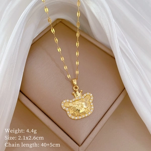 Detailed view of a gold crown pendant necklace with inset diamonds in a jewelry box