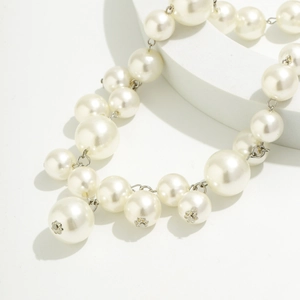 Detail of faux pearl fringe necklace with silver floral metal spacers and cream beads