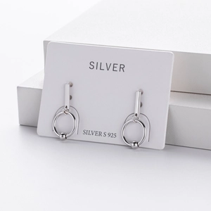 Macro shot of S925 sterling silver geometric drop earrings with hollow round hoops