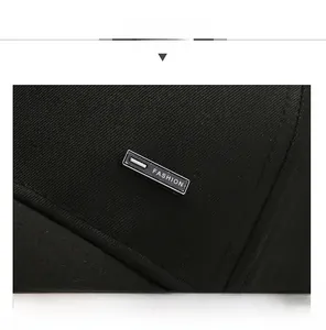 Détail d'une casquette en sergé de coton noir avec logo métallique et coutures précises
