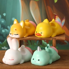 Detail of cute animal figurines including fox, duck, rabbit and unicorn on a wooden floor
