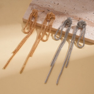 Detail view of long tassel knot earrings with fine metal woven chains in gold and silver