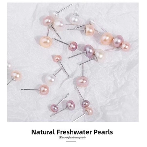 Macro shot of natural freshwater pearl earrings in white pink and purple tones